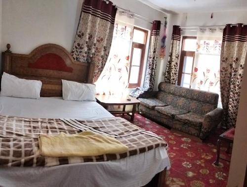 une chambre d'hôtel avec un lit et un canapé dans l'établissement Double tree irshad, à Srinagar