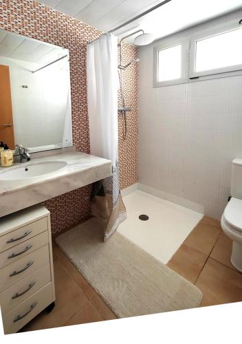 a bathroom with a sink and a shower with a mirror at Casa Pascal cœur du Delta in L'Ampolla