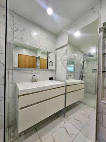 a white bathroom with a sink and a mirror at Big Windows, Endless Views by Pintar Apartments in Bohinjska Bela