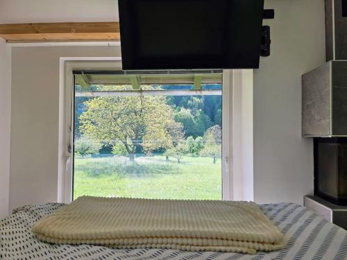 a bed in a room with a large window at Big Windows, Endless Views by Pintar Apartments in Bohinjska Bela