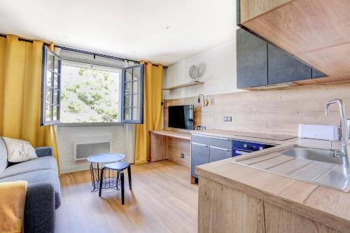 une cuisine et un salon avec un canapé et une table dans l'établissement Madeleine 13 - Charmant studio pour 2, à Fréhel