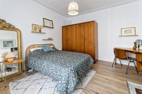 une chambre avec un lit, un bureau et un miroir dans l'établissement Le Cosy Hermite, à Nancy