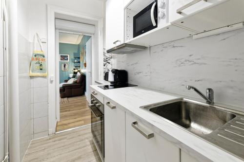 une cuisine avec un évier et un micro-ondes dans l'établissement Le Cosy Hermite, à Nancy
