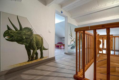 Dinosaur House في كول دي نارجو: تمثال ديناصور على جدار في الممر