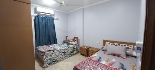 um pequeno quarto com 2 camas e uma janela em Ikea flat 10 em Hurghada