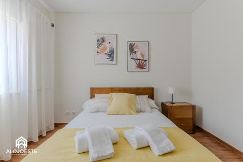 una camera da letto con un letto grande con due asciugamani bianchi di Villa Penafirme - Santa Cruz a Santa Cruz