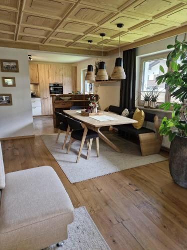 a living room with a table and a kitchen at Haus Egger in Jochberg