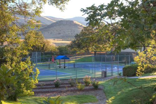 a tennis court with mountains in the background at Ashland Hills Hotel & Suites in Ashland