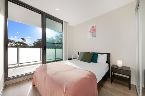 a bedroom with a bed and a large window at KozyGuru | Wentworthville | 2 Bed 2 Bath Apt in Wentworthville