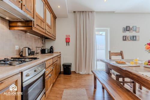 una cucina con mobili in legno e un piano di lavoro di Villa Penafirme - Santa Cruz a Santa Cruz