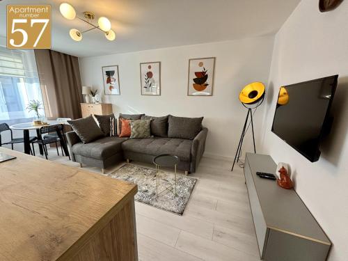 a living room with a couch and a tv at Piękny przytulny apartament - blisko akwenu wodnego in Radom