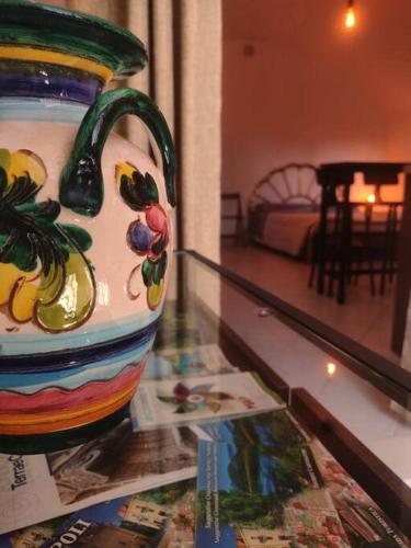 a colorful vase sitting on top of a glass table at Monò in Popoli