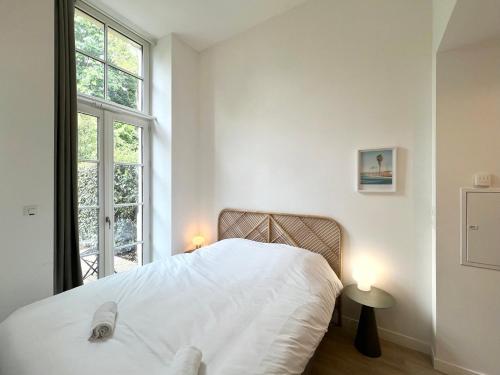 une chambre avec un lit blanc et une fenêtre dans l'établissement Le Clos Demoiselles, à Poitiers
