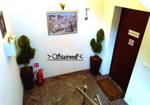 a room with two potted plants on the wall at House White Stone Split in Podstrana