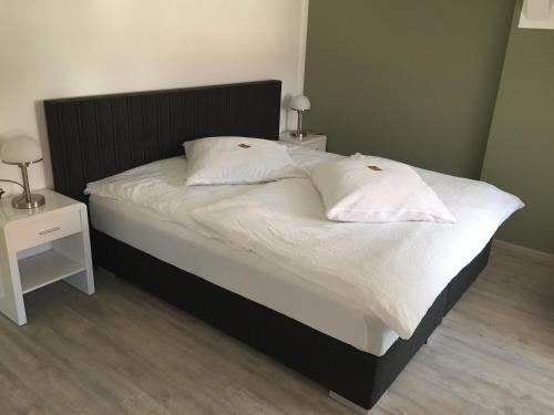 ein Bett mit zwei weißen Kissen darauf im Schlafzimmer in der Unterkunft Elbsandstein Apartments in Meißen