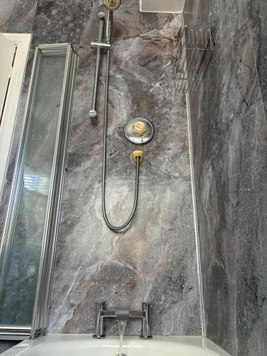 a shower in a bathroom with a sink at Gwynarth Guest House in Wadebridge