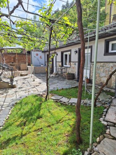 a house with a yard with a patio at Musala 1 Bed & Breakfast in Kyustendil