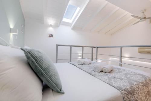 Un dormitorio blanco con una cama con toallas. en Viatzo Loft Apartment en Potamós