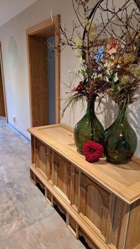 two vases sitting on top of a wooden table with flowers at Haus Egger in Jochberg