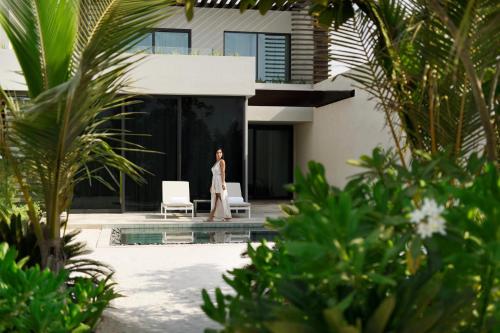 a woman walks in front of a house at Mövenpick Resort Al Marjan Island in Ras al Khaimah