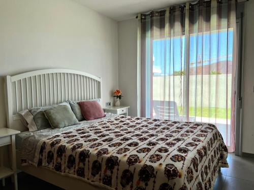 um quarto com uma cama e uma grande janela em Apartment 2 bedrooms and terrace em La Tejita