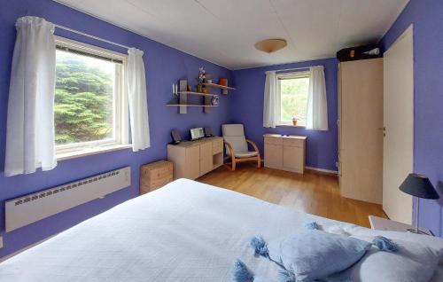 Dormitorio azul con cama y escritorio en 4 Bedroom Nice Home In Örkeljunga, en Orkelljunga