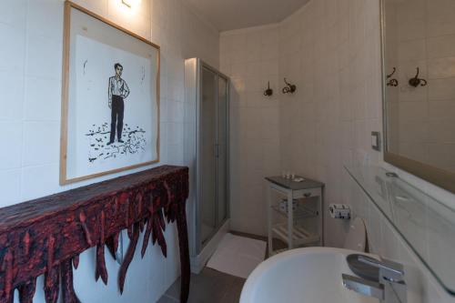 ein Badezimmer mit einem Bild eines Mannes an der Wand in der Unterkunft La dimora degli artisti in Torre Alfina