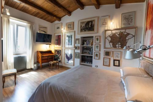 ein Schlafzimmer mit einem großen Bett und Bildern an der Wand in der Unterkunft La dimora degli artisti in Torre Alfina