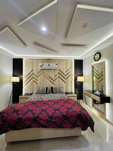 1 dormitorio con 1 cama grande y reloj en la pared en Luxury 1-Bed Apartment Bahria en Lahore