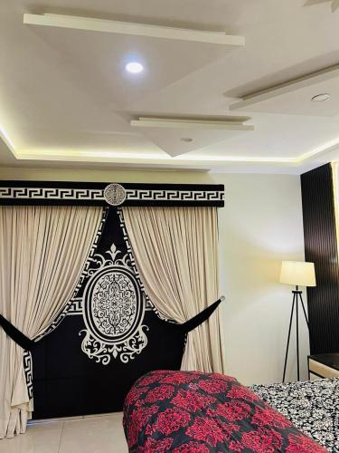 1 dormitorio con 1 cama y cortina en blanco y negro en Luxury 1-Bed Apartment Bahria en Lahore