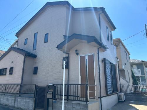 a white house with a blue roof at 近藤沢駅の新装リノベーション一軒家 3LDK、無料駐車場完備、最大7名様までご利用可能 in Fujisawa