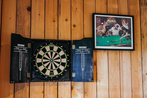 a dartboard and two pictures on a wall at 9 Eagles Eyrie, Camp Tapnell in Yarmouth