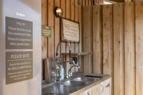 a kitchen with a sink and wooden walls at 9 Eagles Eyrie, Camp Tapnell in Yarmouth