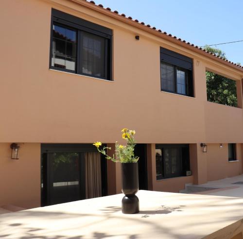 a vase with flowers in front of a house at ALFIEA HOME 65m2 & ALFIEA STUDIO 35m2 in Artemida