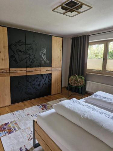 a bedroom with two beds and a chair at Haus Egger in Jochberg