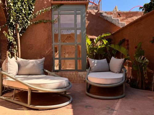 two chairs sitting on a patio next to a window at CASA ABRACADABRA in Marrakech