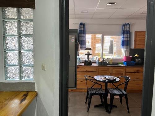 a kitchen with a table and two chairs in it at Résidence Bleu Rivage in Diego Suarez