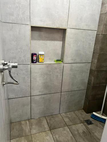 - une cabine de douche avec une étagère dans la salle de bains dans l'établissement Résidence Bleu Rivage, à Diego Suarez