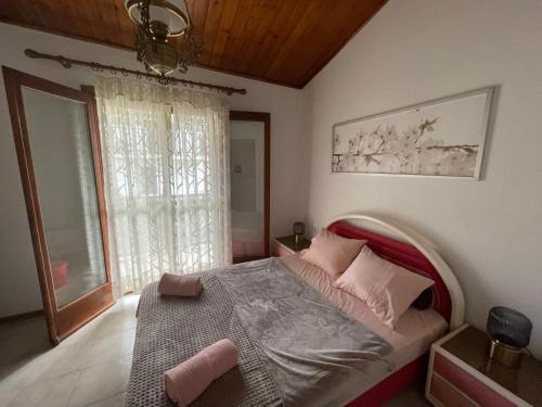 a bedroom with a bed and a window at Superior Maisonette, Trikorfo Beach, Gerakini, Chalkidiki in Yerakiní
