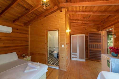 1 dormitorio con 1 cama en una habitación de madera en Aylin Ahşap Evler en Yakaköy