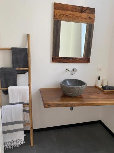 ein Badezimmer mit einem Waschbecken und einem Spiegel auf der Theke in der Unterkunft Simi's Home in Gordevio