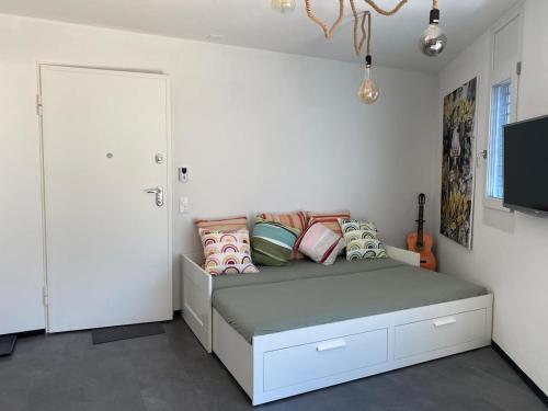 Schlafzimmer mit einem Bett mit Kissen und einem TV in der Unterkunft Simi's Home in Gordevio
