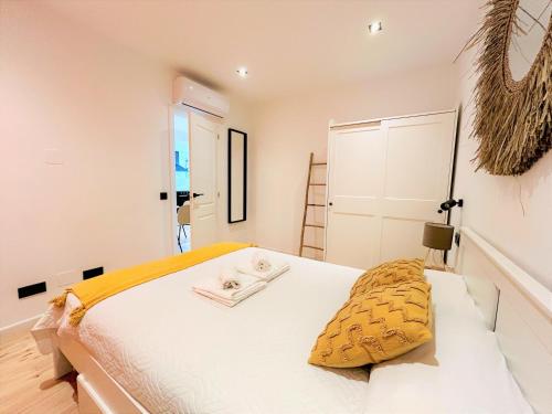 a bedroom with a large white bed with yellow sheets at Ecochic Apartment in Fuengirola Center in Fuengirola