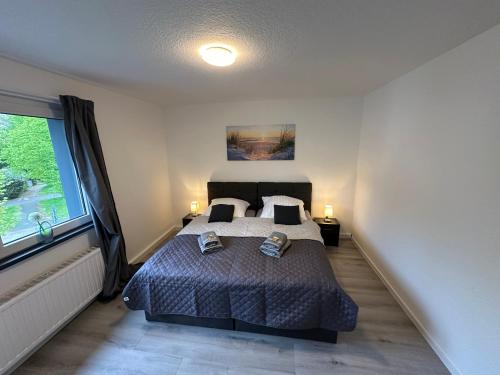 a bedroom with a bed and a large window at Moderne Ferienwohnung für 4-5 Personen mitten in Herten*Netflix*Nespresso in Herten