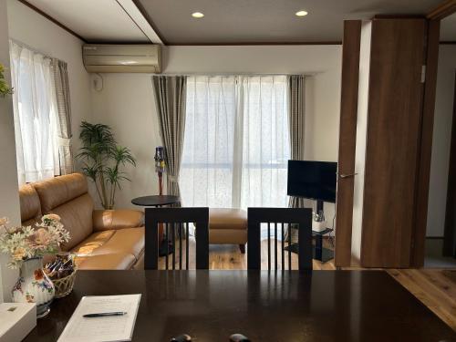 a living room with a table and a couch at 近藤沢駅の新装リノベーション一軒家 3LDK、無料駐車場完備、最大7名様までご利用可能 in Fujisawa
