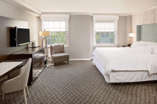 Habitación de hotel con cama blanca grande y escritorio. en The Westin Governor Morris, Morristown en Morristown