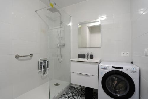 La salle de bains blanche est pourvue d'un lave-linge et d'une douche. dans l'établissement Le Douillet - Aux portes de Paris - 323B, à Rueil-Malmaison