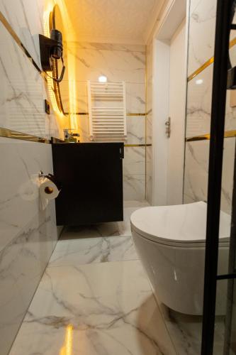 a white bathroom with a toilet and a sink at COMFORT HOUSE HOTEL in Pelitli