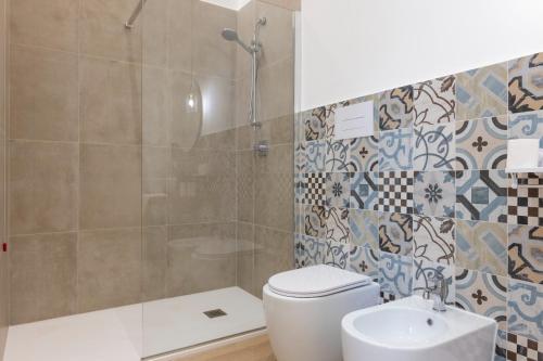 a bathroom with a shower and a toilet and a sink at Palazzo Quattrone in Reggio Calabria