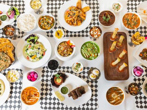 a table full of plates of food on a table at Sunday Hotel Chandigarh Zirakpur in Zirakpur